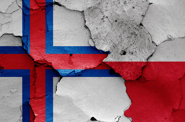 flags of Faroe Islands and Poland painted on cracked wall