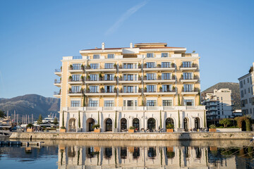 Regent Hotel on the shore is reflected in the sea. Porto, Montenegro