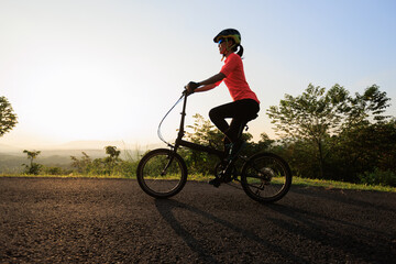 Fototapeta na wymiar Riding folding bike on sunny mountain top road