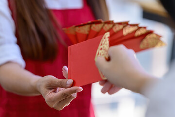 The hand receives a red envelope of Ang Pao for Chinese New Year
