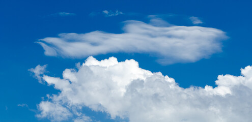 Fluffy white cumulus clouds in a blue sky on a beautiful day, natural soft background with copy space for text