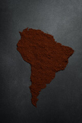 Coffee. Map of South America laid out from coffee. Fragrant roasted Robusta or Arabica coffee. Top view. On a black stone table.