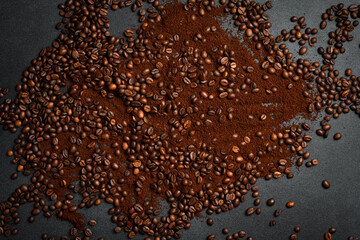 Roasted coffee beans and ground coffee on a black stone table. Aromatic coffee.