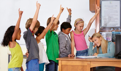 Fototapeta premium Teacher woman, class and children with raised hand for questions, answer or pop quiz with headache. Teaching person, school kids and education for development, scholarship or assessment at academy