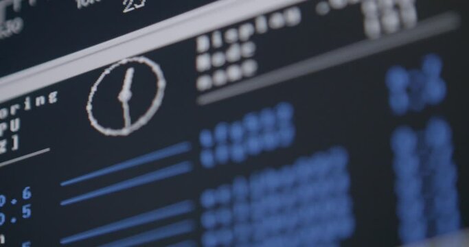 Close-up of a computer monitor displaying system monitoring software with graphs and CPU usage