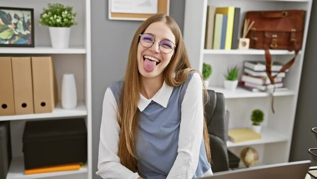 Funny expression fills the office! young blonde business woman happily sticks her tongue out, adding a dash of fun and positive emotion to the workplace