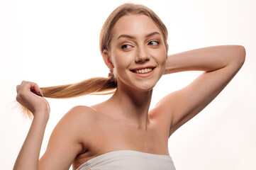 Beautiful beauty portrait of a smiling blonde girl on an isolated white background. Skin care concept