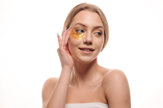 Beauty portrait of girl applying gel eye patches on face isolated on white background
