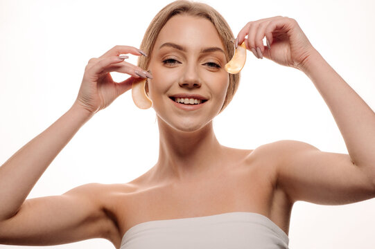 Beauty portrait of girl applying gel eye patches on face isolated on white background