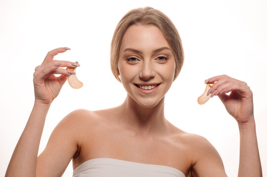 Beauty portrait of girl applying gel eye patches on face isolated on white background