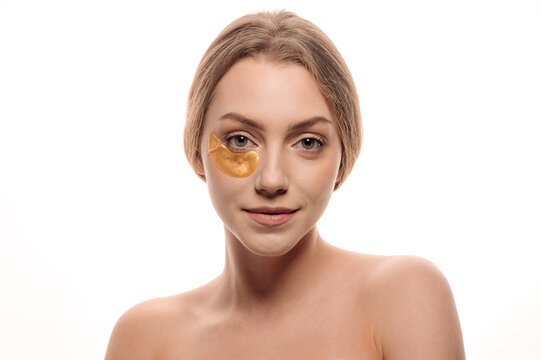 Beauty portrait of girl applying gel eye patches on face isolated on white background