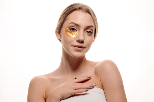 Beauty portrait of girl applying gel eye patches on face isolated on white background