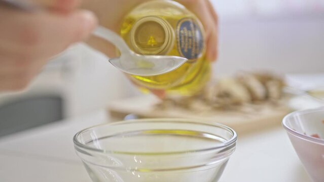 Woman Measuring Olive Oil In Tablespoons