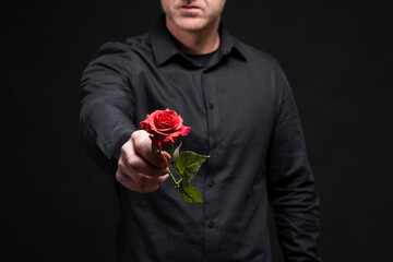Hombre entregando una flor rosa roja