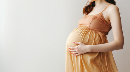 Pregnant Woman Cradling Belly in Yellow Dress - obrazy, fototapety, plakaty