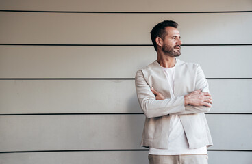 Portrait of handsome confident stylish hipster lambersexual model. Sexy modern man dressed in elegant suit. Fashion male posing in the street near urban wall