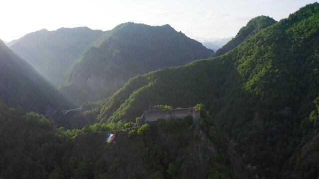 Poenari fortress in Romania. Aerial 4k video with this amazing fortress on top of a peak hill from Fagaras Mountains, the place where Vlad Dracula lived. Travel to Romania landmarks. Sunset sky.