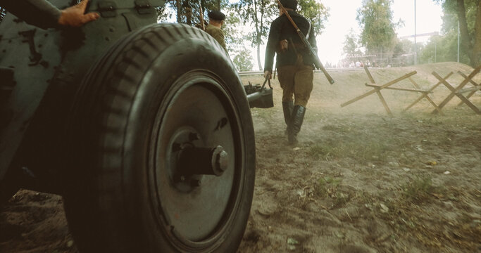 Preparing For Historical Reenactment. Group Of Re-enactors Dressed As Russian Soviet Red Army Infantry Soldiers Of World War Ii Are Move Soviet 45mm Anti-tank Gun To Combat Position.