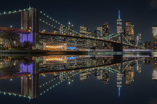 view of the brooklin bridge at night with reflections. manhattam skyline, brooklyn bridge. New York City