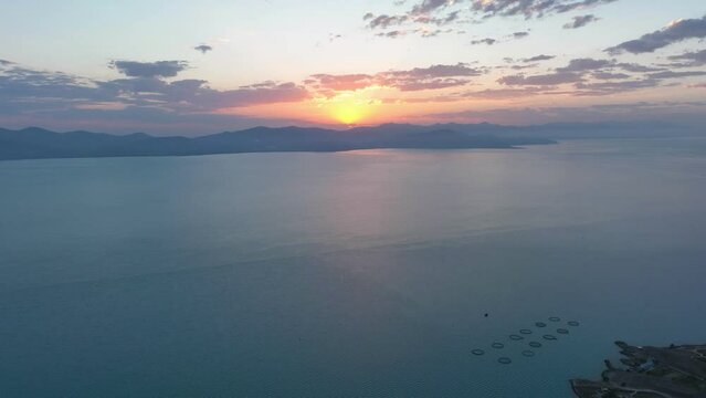 Scenic sunset or sunrise over Sevan lake popular holiday destination in Armenia, Caucasus, West Asia. Daytime Timelapse of moving white, grey clouds over lake Sevan on background hills