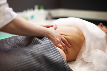 Fototapeta na wymiar Young woman having stomach massage