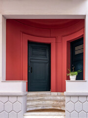 Stylish town house entrance in green and reddish tones, framed in beige. Athens downtown, Greece.