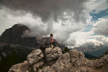 Woman traveler traveling alone in breathtaking landscape of Dolomites Mounatains. Travel lifestyle wanderlust adventure concept.