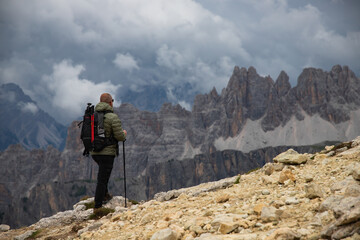 Fototapeta premium Man traveler traveling alone in breathtaking landscape of Dolomites Mounatains. Travel lifestyle wanderlust adventure concept.