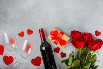 Fototapeta na wymiar Valentine's Day concept. Valentine's Day background. Gifts, candles, confetti, envelope - postcard, sweets, glasses, wine and a bouquet of roses on a marble background. Flatley, top view.