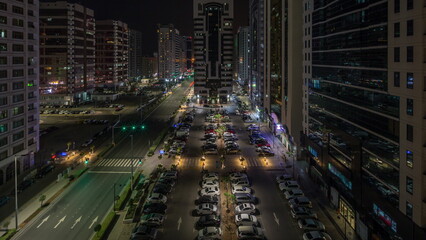 Residential buildings and modern city architecture of Abu Dhabi aerial timelapse during all night,...