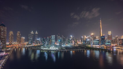 Fototapeta na wymiar Aerial view to Dubai Business Bay and Downtown with the various skyscrapers and towers night timelapse