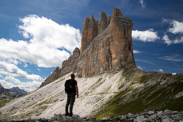 Fototapeta premium Stunning view of a tourist enjoying the view of the Tre Cime Di Lavaredo, Dolomites, Italy.