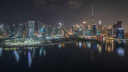 Fototapeta na wymiar Panorama showing aerial view to Dubai Business Bay and Downtown with the various skyscrapers and towers night timelapse
