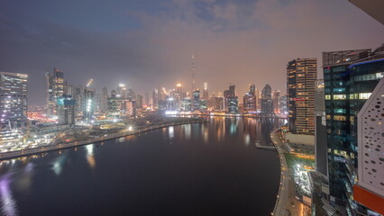 Aerial skyline of Dubai Business Bay and Downtown with the various skyscrapers and towers day to night timelapse