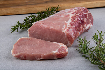 raw pork pig meat loin on grey background with wooden board