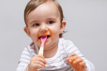 Eating, cute and boy baby in chair with vegetable food for child development at home. Sweet, nutrition and hungry young kid or toddler enjoying healthy lunch, dinner or supper meal at house.