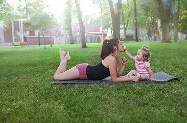 Woman exercising with her baby girl in the park