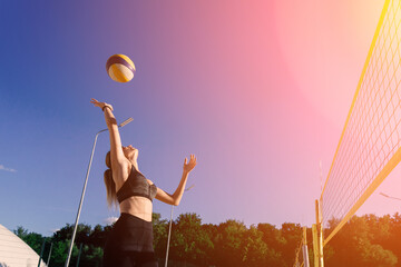 A female beach volleyball athlete with ball on the volleyball court