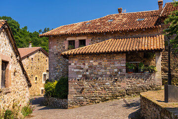 Old stone mountain mansions with red roofs. Carmona, Cantabria, Spain.