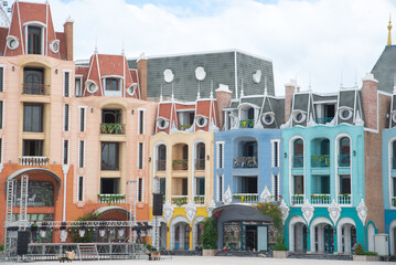 Row of colorful shophouses painted upscale townhome duplex with decorated balcony flower decoration, upscale row of multistory houses for retail, boutique, tourist attraction in Vietnam