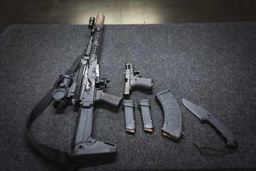 Weapons in a shooting range, an AKM rifle with a silencer and a weapon flashlight, a G19 pistol,...