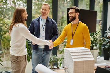 cheerful handsome architects in casual outfits working together on their startup, coworking concept