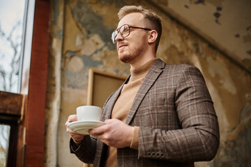 joyous sophisticated business leader with glasses in elegant suit drinking his hot coffee