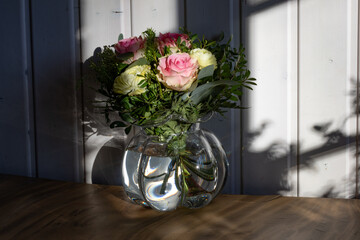 Pastell Blumenstrauß von weißen und rosa Rosen angeleuchtet von der Winter Sonne draussen mit dem...