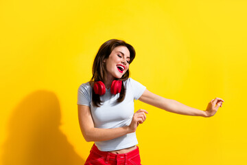 Photo of pretty funky woman dressed white t-shirt headphones dancing discotheque isolated yellow color background