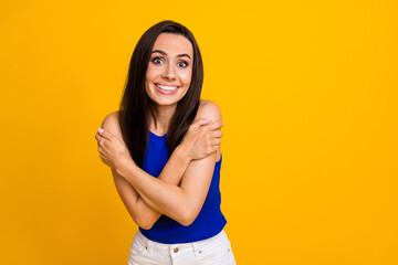 Photo of pretty funky lady dressed blue top freezing hugging herself empty space isolated yellow color background