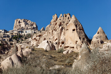 View of Uchisar Castle in Cappadocia, Turkey and several old troglodyte settlements. Uchisar Castle is a tall volcanic-rock outcrop and is one of Cappadocia's most prominent landmarks.