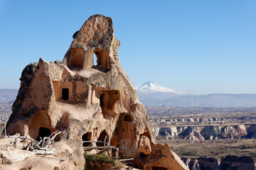 View of an old troglodyte settlement in Uchisar with Mount Erciyes in the background. Travel...