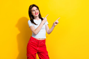 Fototapeta na wymiar Portrait of adorable girl with brunette hair wear white t-shirt directing look at sale empty space isolated on yellow color background