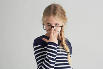 Child, portrait and glasses with serious in mockup, thought and eyewear or nose in studio. Girl, face or geek with blonde hair in fashion with vision, contemplation or smart kid by white background - obrazy, fototapety, plakaty